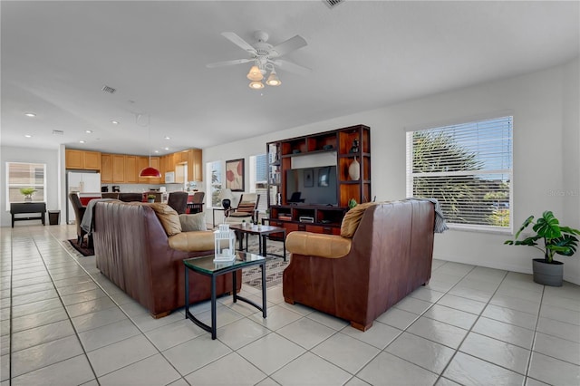 living room with light tile patterned floors, ceiling fan, and a healthy amount of sunlight