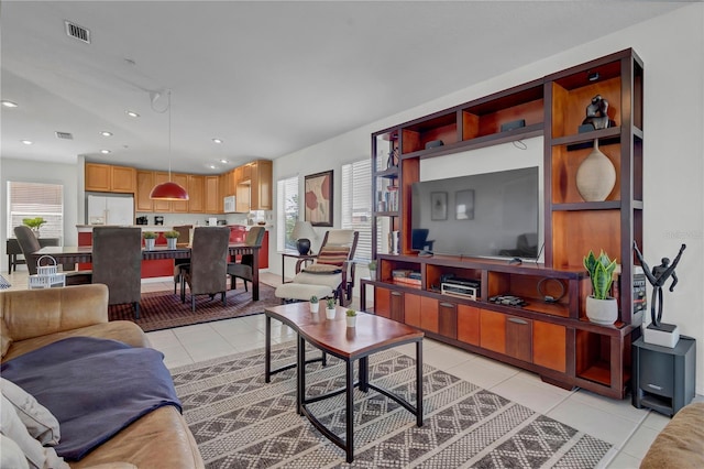 living area with a healthy amount of sunlight, light tile patterned flooring, and visible vents