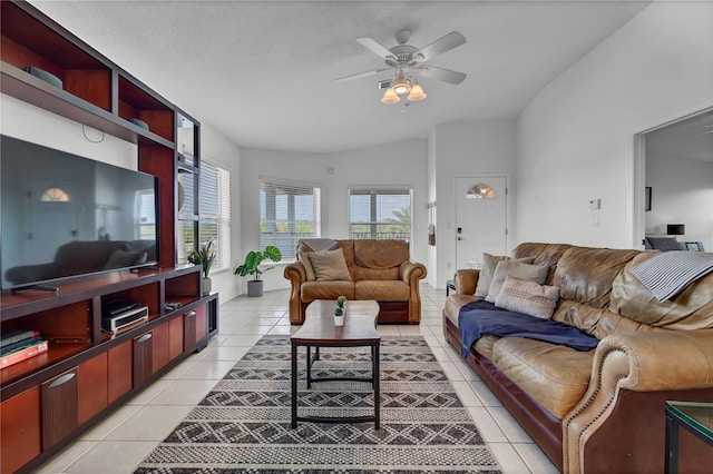 living room featuring a textured ceiling, ceiling fan, light tile patterned floors, and lofted ceiling