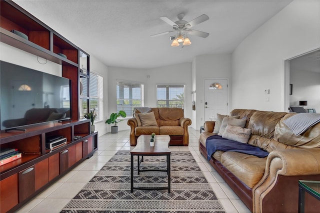 living room featuring vaulted ceiling, a ceiling fan, and light tile patterned flooring