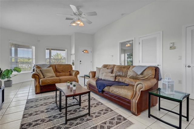 living room with ceiling fan, vaulted ceiling, and light tile patterned flooring