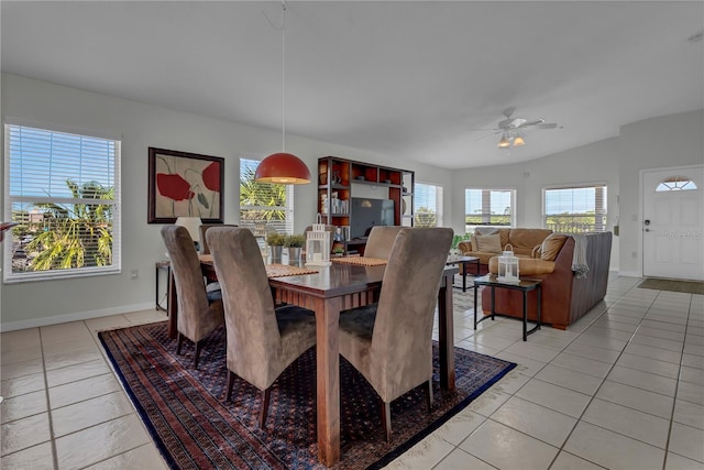 dining space featuring lofted ceiling, baseboards, a ceiling fan, and light tile patterned flooring