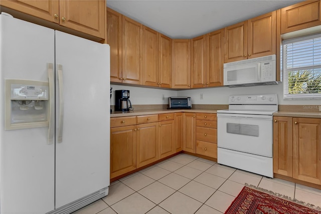 kitchen with a toaster, white appliances, light countertops, and light tile patterned flooring