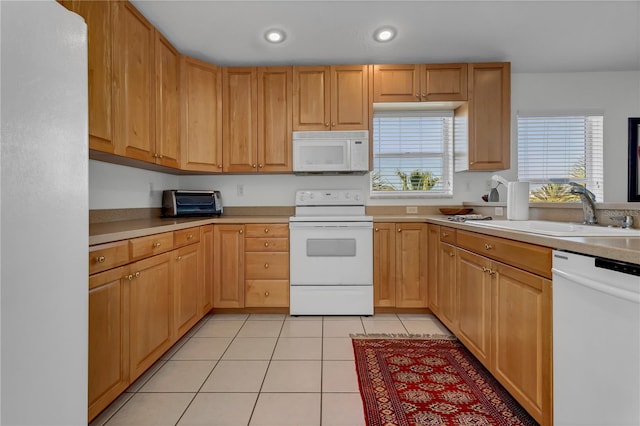 kitchen with light tile patterned floors, sink, and white appliances