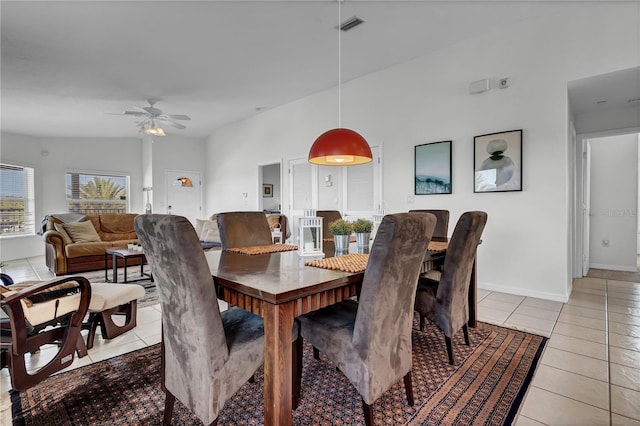 tiled dining room with ceiling fan and vaulted ceiling