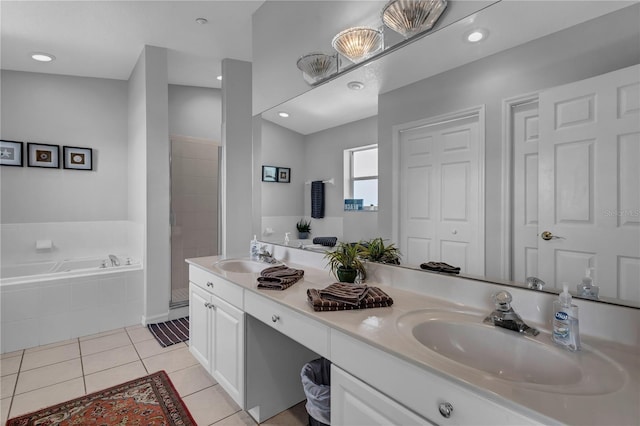 full bathroom featuring a sink, tile patterned floors, double vanity, and a garden tub