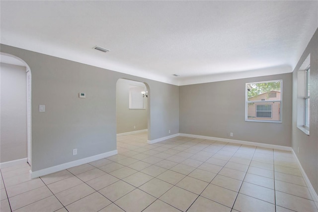 empty room featuring light tile floors and a textured ceiling