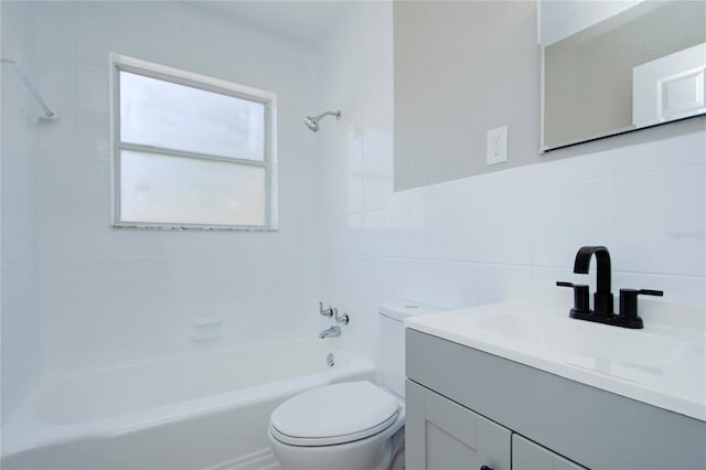 full bathroom featuring tiled shower / bath, tile walls, large vanity, tasteful backsplash, and toilet