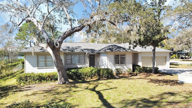 single story home featuring a front yard and a garage