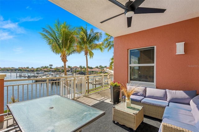 view of patio with an outdoor living space, ceiling fan, and a water view