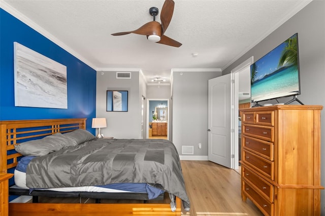 bedroom featuring ensuite bathroom, light hardwood / wood-style flooring, ceiling fan, crown molding, and a textured ceiling