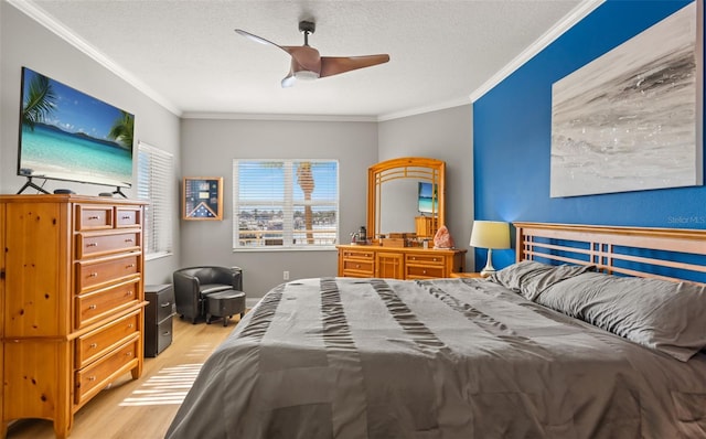 bedroom with ornamental molding, ceiling fan, light wood-type flooring, and a textured ceiling