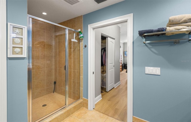 bathroom featuring hardwood / wood-style flooring and a shower with door