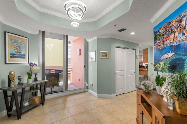 tiled entrance foyer with ornamental molding and a raised ceiling