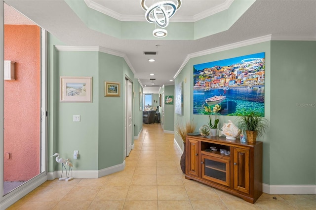 corridor with crown molding, tile floors, and a tray ceiling