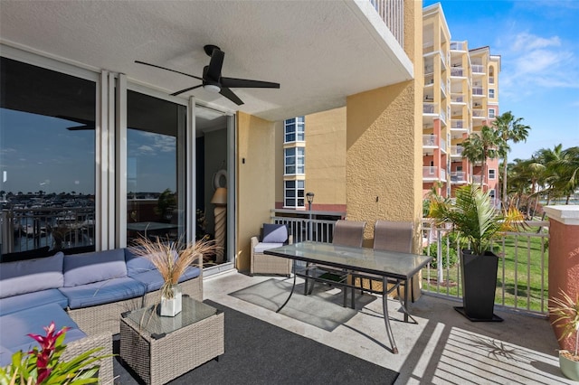 view of patio with outdoor lounge area, ceiling fan, and a balcony