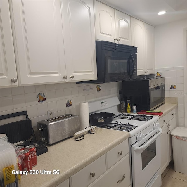 kitchen with tasteful backsplash, white cabinetry, white range with gas stovetop, and light tile floors