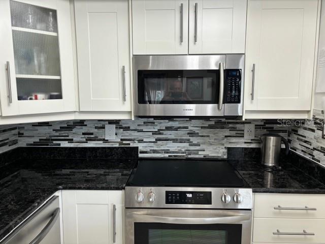 kitchen with tasteful backsplash, stainless steel appliances, and white cabinetry