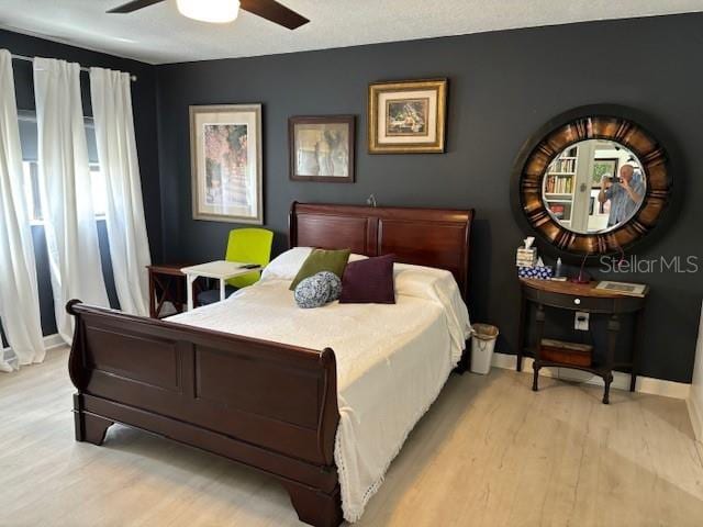 bedroom with light hardwood / wood-style floors and ceiling fan