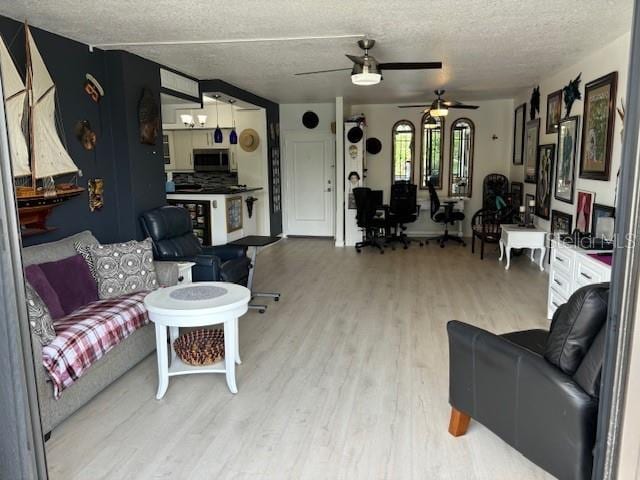 living room with wood-type flooring, ceiling fan, and a textured ceiling