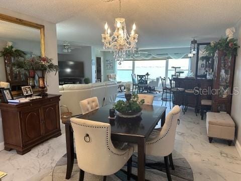 dining room featuring a textured ceiling and ceiling fan with notable chandelier