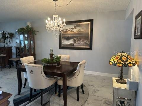 dining room featuring an inviting chandelier and a textured ceiling