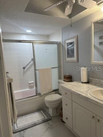 full bathroom featuring vanity, a textured ceiling, ceiling fan, bath / shower combo with glass door, and toilet