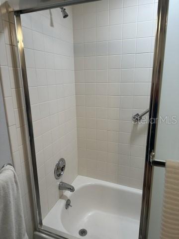 bathroom featuring shower / bath combination with glass door