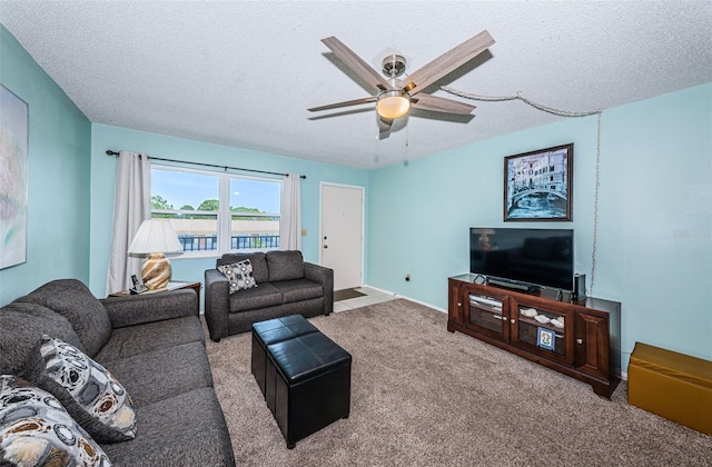 carpeted living room featuring ceiling fan and a textured ceiling