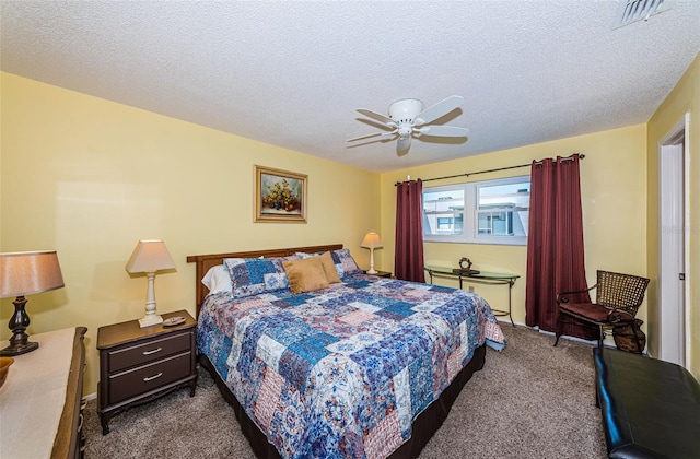 carpeted bedroom featuring ceiling fan and a textured ceiling