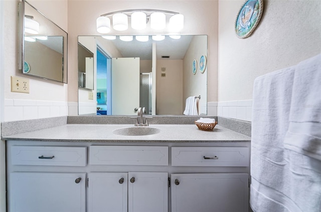 bathroom with vanity with extensive cabinet space and backsplash