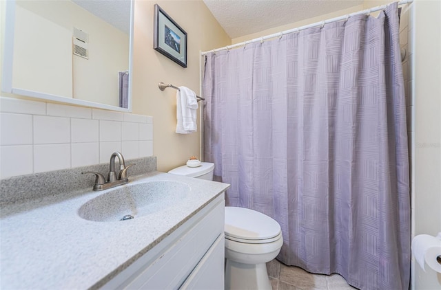 bathroom featuring vanity, tile flooring, tasteful backsplash, toilet, and a textured ceiling