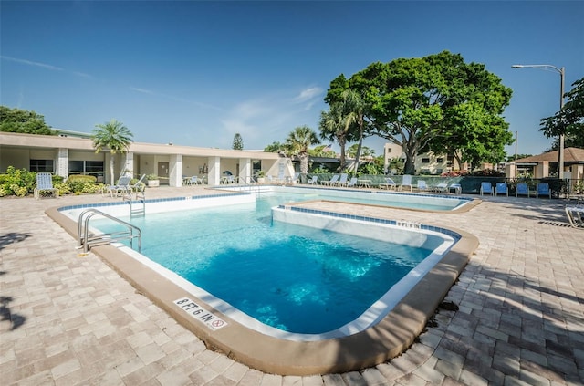 view of swimming pool featuring a jacuzzi and a patio