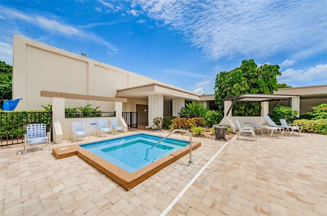 view of swimming pool featuring a hot tub and a patio area