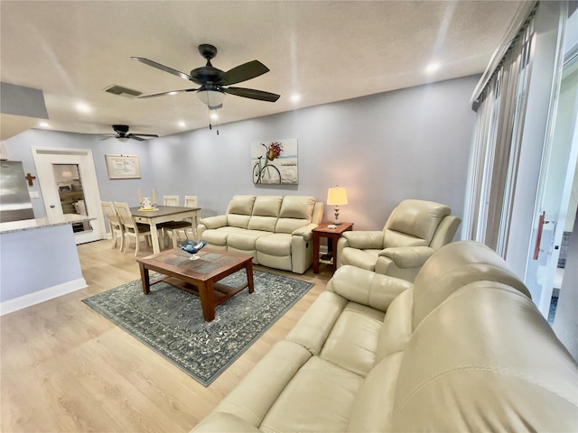 living room featuring ceiling fan and light hardwood / wood-style floors