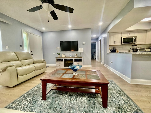 living room with light wood-type flooring and ceiling fan