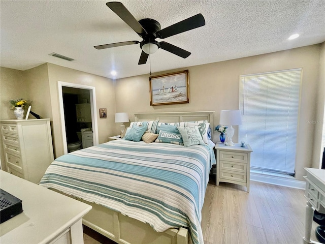 bedroom featuring a textured ceiling, ceiling fan, and light wood-type flooring