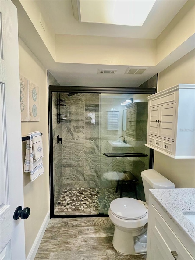 bathroom with vanity, toilet, hardwood / wood-style floors, and an enclosed shower