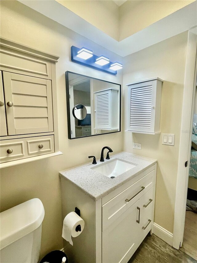 bathroom featuring vanity, toilet, and hardwood / wood-style flooring