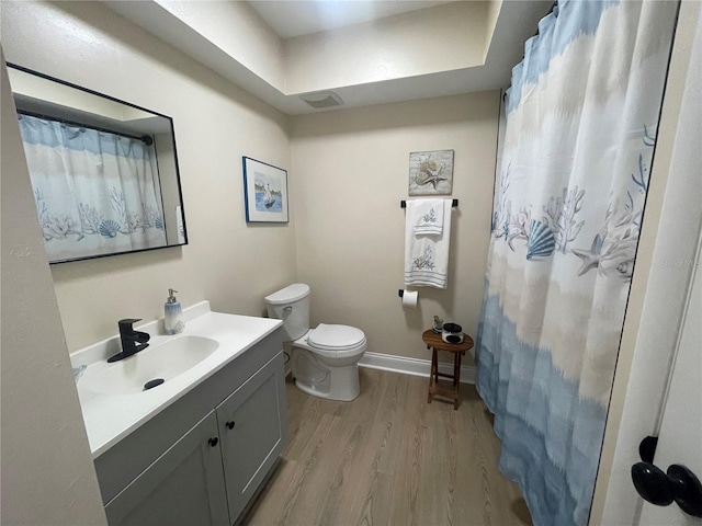 bathroom featuring vanity, toilet, curtained shower, and hardwood / wood-style floors