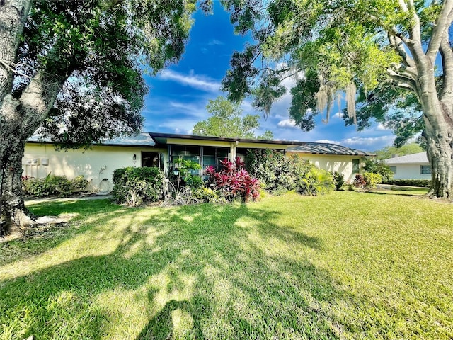 view of front of property featuring a front lawn and stucco siding