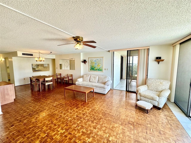 living room with floor to ceiling windows, visible vents, a textured ceiling, and ceiling fan with notable chandelier