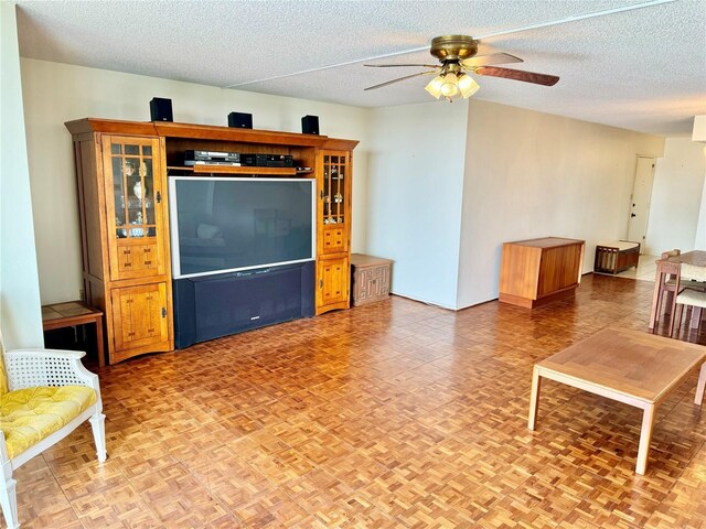 living room featuring a textured ceiling and ceiling fan