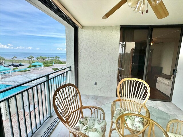 balcony with a water view and ceiling fan