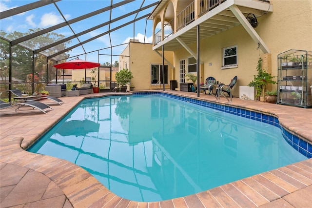 view of swimming pool with a patio area and glass enclosure