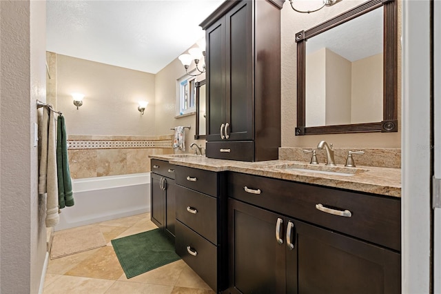 bathroom with tile flooring, a bathtub, vanity with extensive cabinet space, and dual sinks