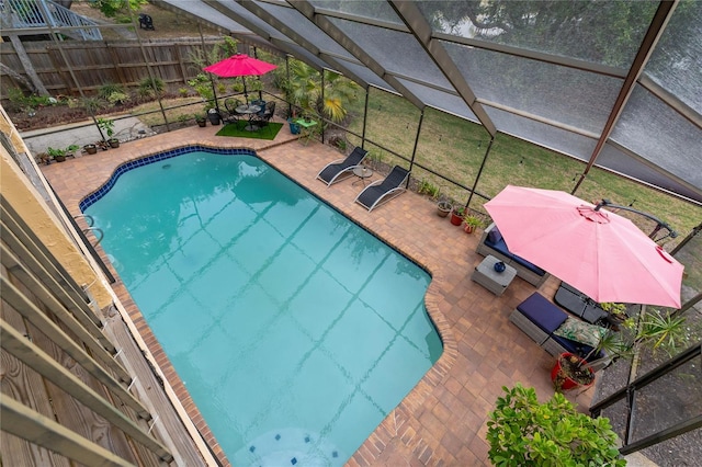 view of pool with glass enclosure and a patio