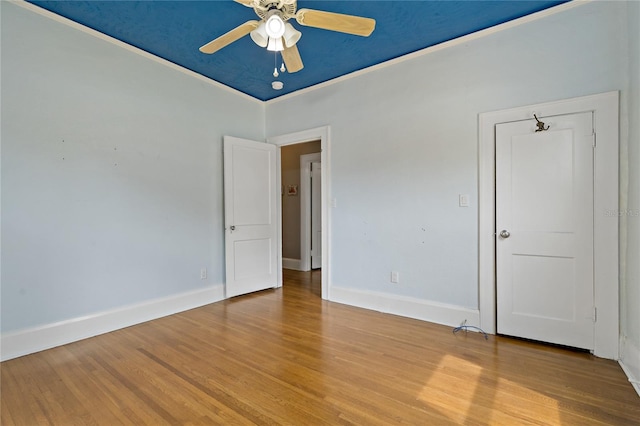 unfurnished bedroom featuring ceiling fan, crown molding, and hardwood / wood-style flooring