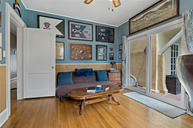 living room with ceiling fan, crown molding, and hardwood / wood-style flooring