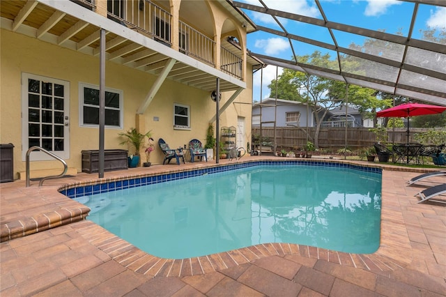 view of pool with a patio area and glass enclosure